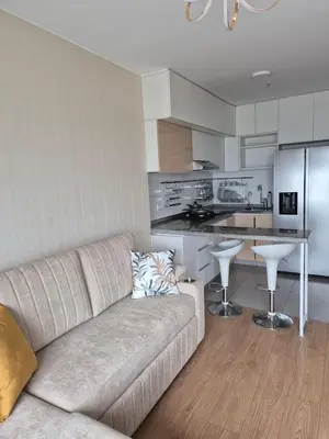 a living room with a couch and a kitchen at Panoramic view apartment in Lima