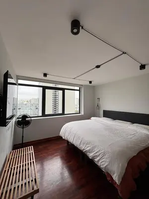a bedroom with a large bed and a bench at Mar Private Rooms in Lima