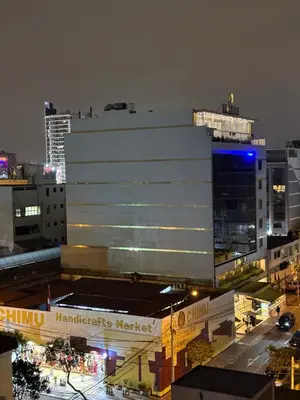a large white building in a city at night at Mar Private Rooms in Lima