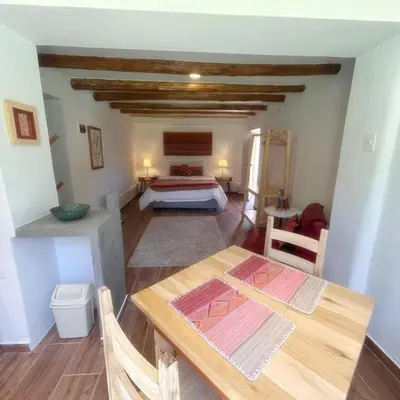 a bedroom with a bed and a wooden table at Chaqra in Urubamba