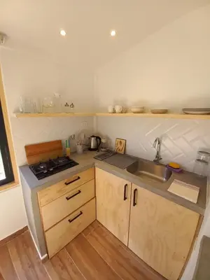 a small kitchen with a sink and a stove at Chaqra in Urubamba
