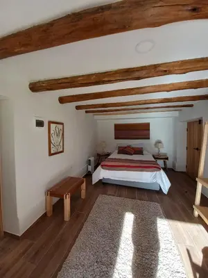 a bedroom with a large bed and wooden ceilings at Chaqra in Urubamba