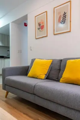 a gray couch with yellow pillows in a living room at Elmora 2BR by Geko in Lima