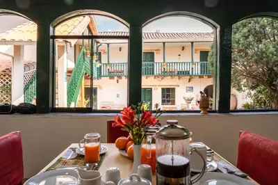 a table in a restaurant with a view of a building at Hospedaje La Florida in Urubamba