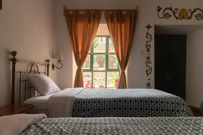 a bedroom with two beds and a window at Hospedaje La Florida in Urubamba