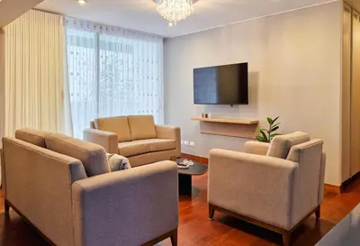 a living room with chairs and a flat screen tv at Meridian 3BR by Geko in Lima