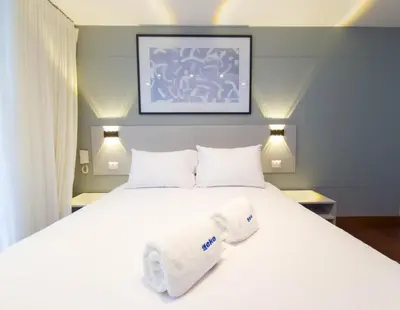 a bedroom with a white bed with towels on it at Meridian 3BR by Geko in Lima