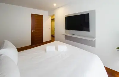 a bedroom with a white bed with a flat screen tv at Meridian 3BR by Geko in Lima