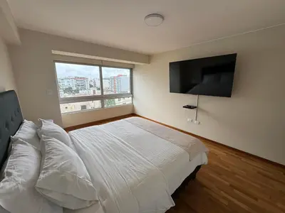 a bedroom with a bed and a flat screen tv at Miraflores 1 Bedroom Executive Apartment in Lima
