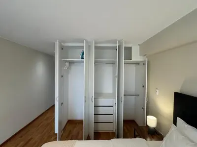 a bedroom with white walls and a bed and a closet at Miraflores 1 Bedroom Executive Apartment in Lima