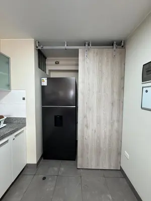 a black refrigerator in a kitchen next to a door at Miraflores 1 Bedroom Executive Apartment in Lima