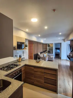 a large kitchen with a stove top and a living room at Hermoso apartamento in Lima