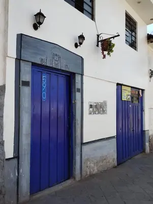 two blue doors on the side of a building at TantaWasi in Cusco