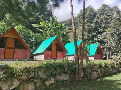 a row of cottages with blue roofs at Lucmabamba Cottage in Sahuayacu