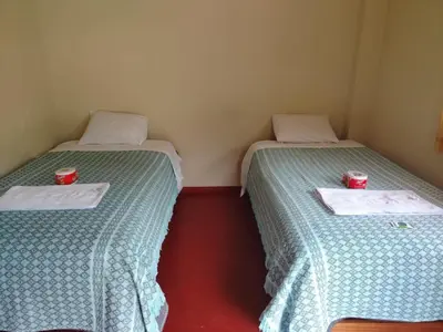 two beds in a room with two cups on them at Lucmabamba Cottage in Sahuayacu