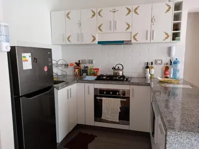 a kitchen with white cabinets and a black refrigerator at Versalles Apartment in Lima