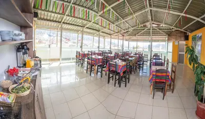 a restaurant with tables and chairs in a room at VILLA andina cusco in Cusco