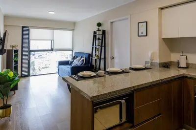 a kitchen and living room with a large counter top at BSR Cozy Flat next to Av. Javier Prado w/ Pool&Gym in Lima