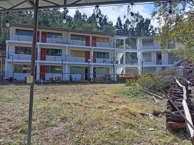 an apartment building with a large yard in front of it at Hotel Campestre Corina