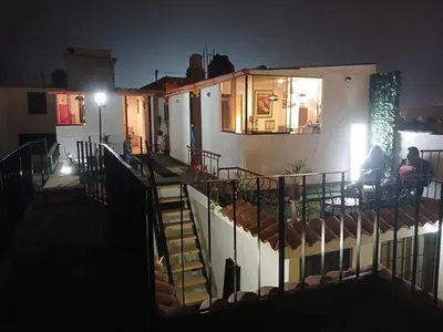 a house at night with people sitting on the balcony at Freestyle Home in Lima