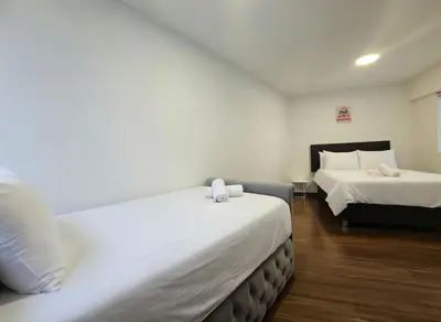 a bedroom with two beds with white sheets and wooden floors at E Malecon Larcomar Free Parking 3B 102 in Lima