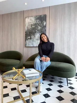 a woman sitting on a green chair in a room at The Sight in Lima