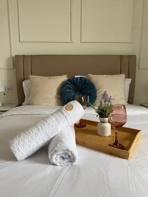 a towel and a glass of wine on a bed at The Sight in Lima