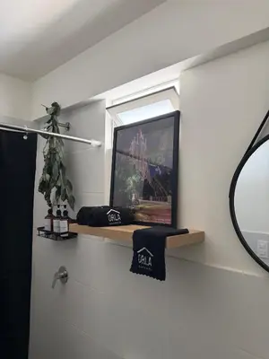 a bathroom with a mirror and a shelf with a window at Casa viajera - orla los topacios in Lima