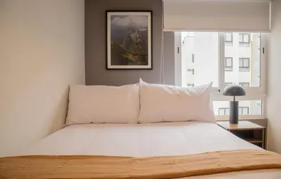 a bedroom with a bed with white pillows and a window at Fanning Apartments by Wynwood House in Lima