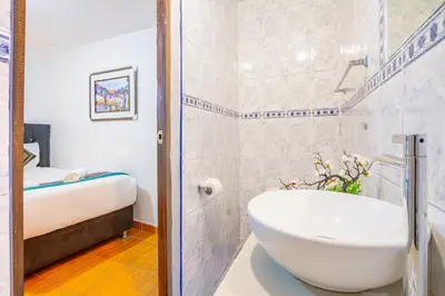 a white bathroom with a tub and a sink at Inkary Hotel Machupicchu in Machu Picchu