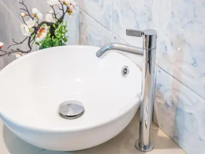 a white sink in a bathroom with a vase of flowers at Inkary Hotel Machupicchu in Machu Picchu