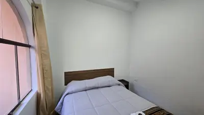 a small white room with a small bed in it at Refugio Sagrado Boutique in Ollantaytambo