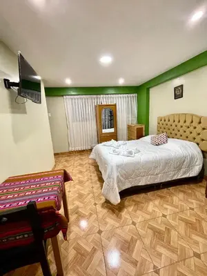 a bedroom with a bed and a television in it at TORIBIANS Hotel in Chinchero