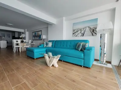 a blue couch in a living room with a table at Confortable con vista al mar de Naplo, Pucusana in Pucusana