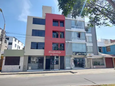 a building with a red facade on a street at Hospedaje El Jardín in Lima