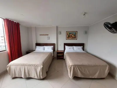 a hotel room with two beds and a window at Hospedaje El Jardín in Lima