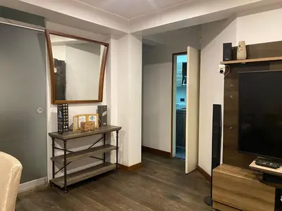 a living room with a flat screen tv and a table at Casa Olivo in Lima