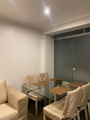 a dining room with a glass table and chairs at Casa Olivo in Lima