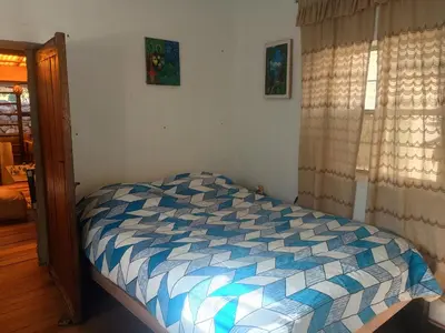 a bedroom with a bed with a blue and white comforter at Yuntawasi Cozy mini Ollantaytambo in Ollantaytambo