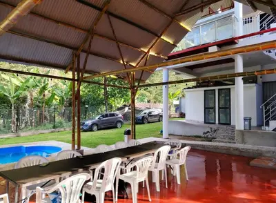 a patio with white chairs and a table and a pool at Casa familiar con parrilla, piscina, WiFi y cesped