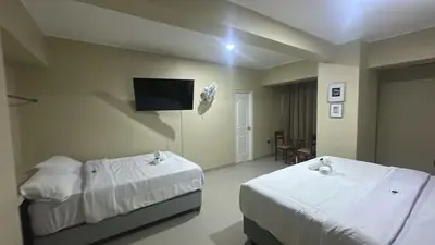 a bedroom with two beds and a tv on the wall at MOON Edificio in San Vicente de Cañete