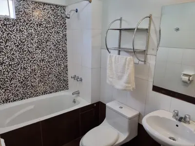 a bathroom with a toilet and a tub and a sink at Departamento acogedor in Abancay