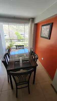 a dining room with a table and chairs and a window at Departamento acogedor in Abancay