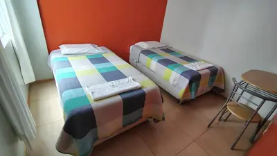 two beds sitting next to each other in a room at Departamento acogedor in Abancay