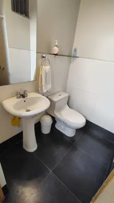 a bathroom with a white toilet and a sink at Departamento acogedor in Abancay