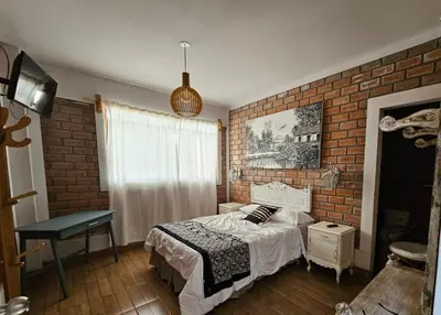 a bedroom with a bed and a brick wall at Hotel Nuestro Amo in Sayán