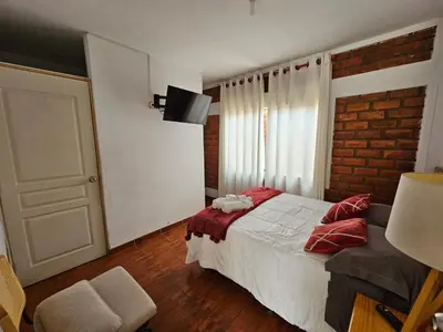 a bedroom with a bed and a brick wall at Hotel Nuestro Amo in Sayán