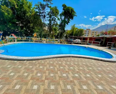 a large blue swimming pool with a fence around it at Hotel Nuestro Amo in Sayán