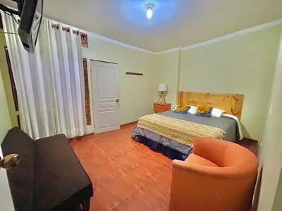 a bedroom with a bed and a couch and a chair at Hotel Nuestro Amo in Sayán