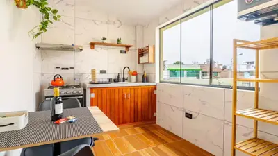 a kitchen with a table and a counter top at Loft equipado y acogedor con Terraza en Matellini in Lima